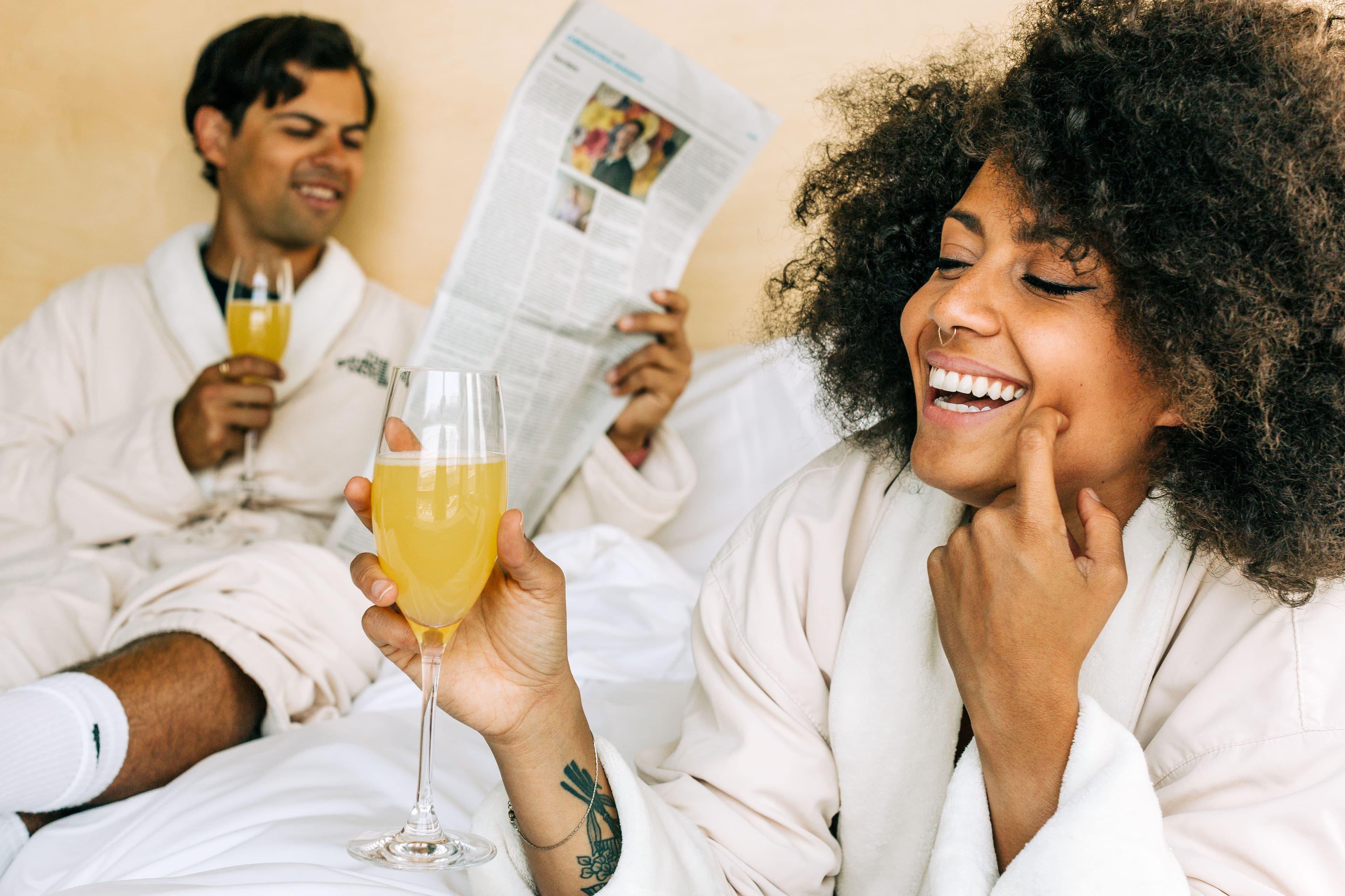 A couple enjoying breakfast in bed together in a hotel room.