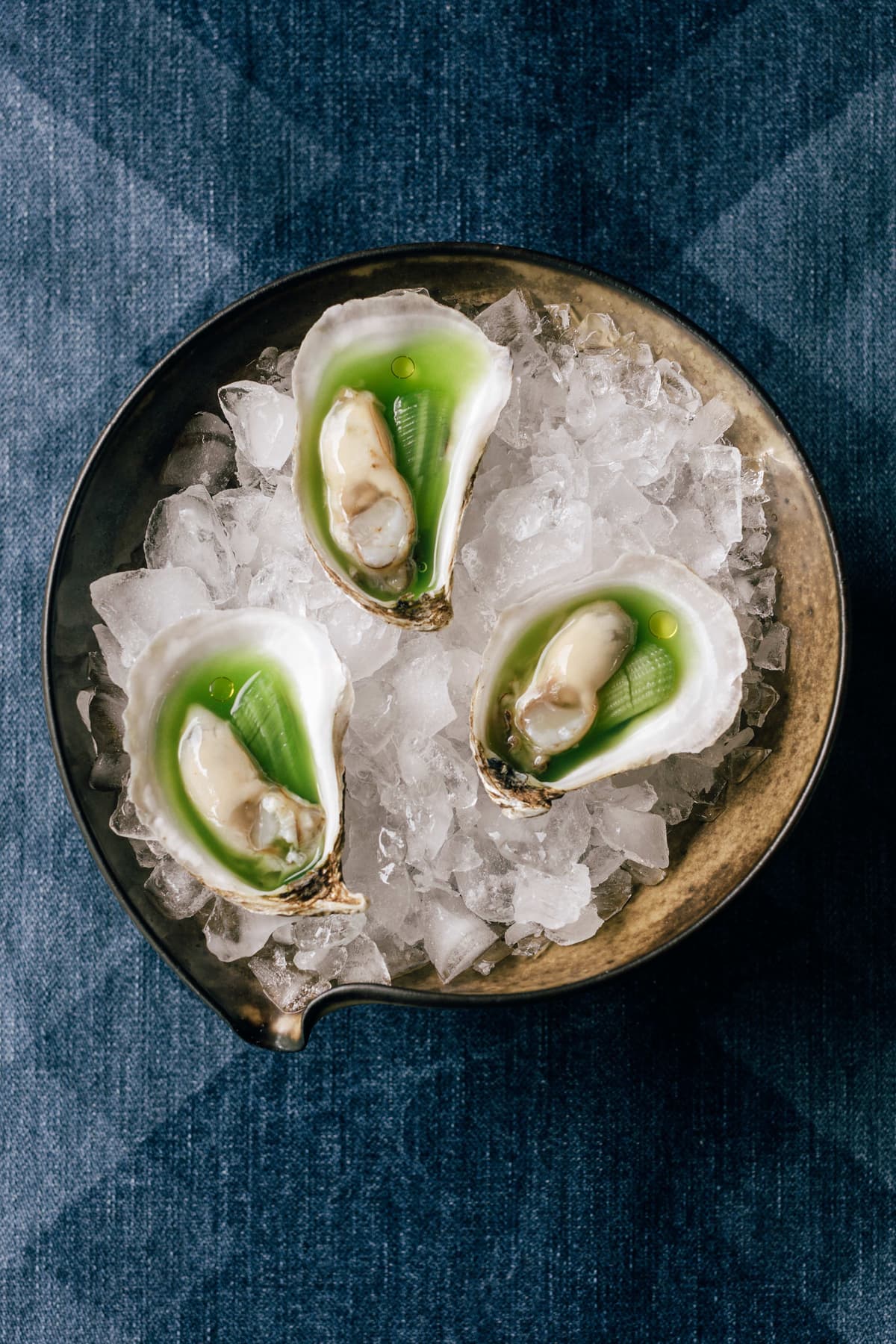 Three oysters on a denim textile.