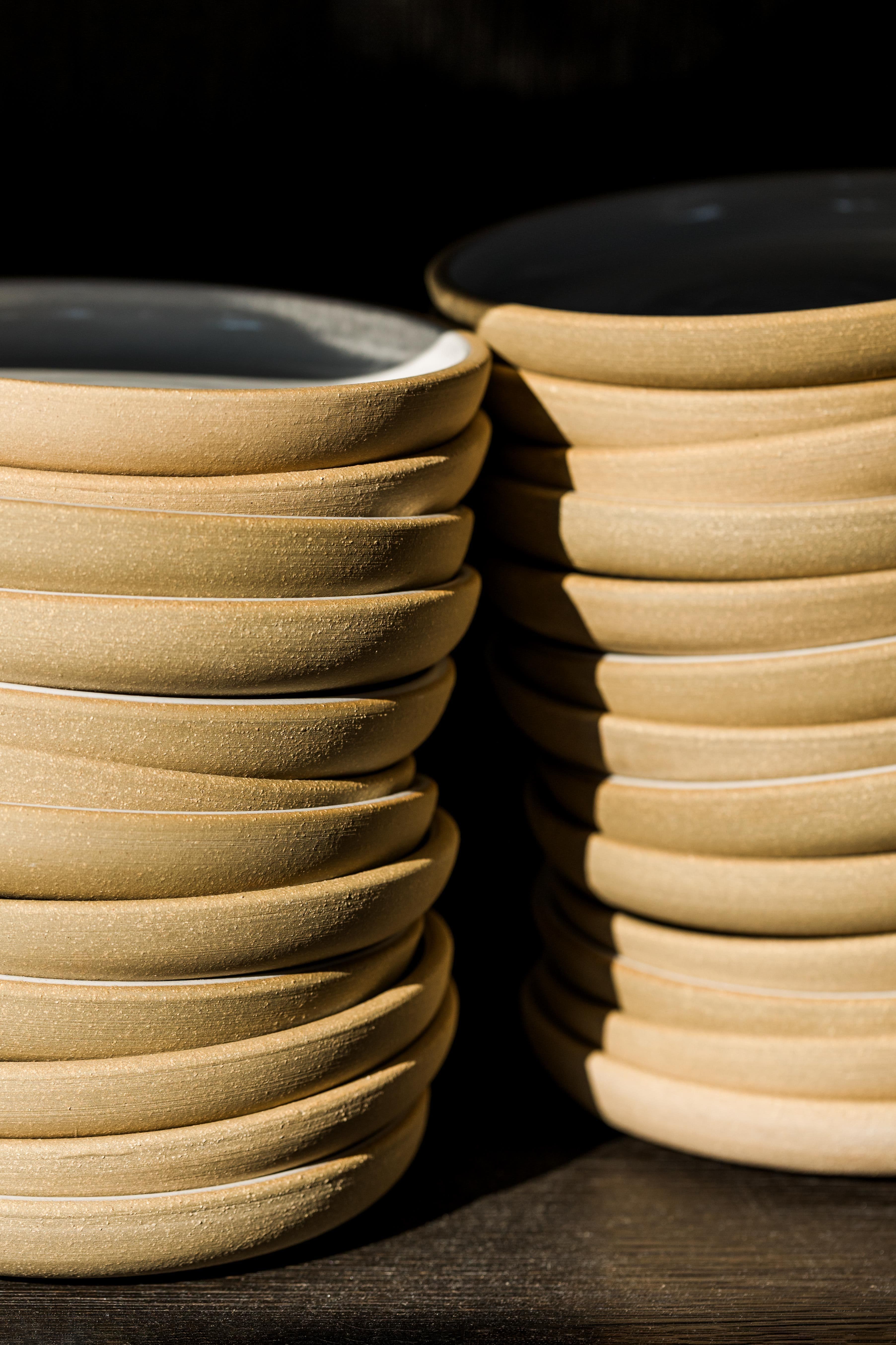 Stacked ceramics glisten in morning light.