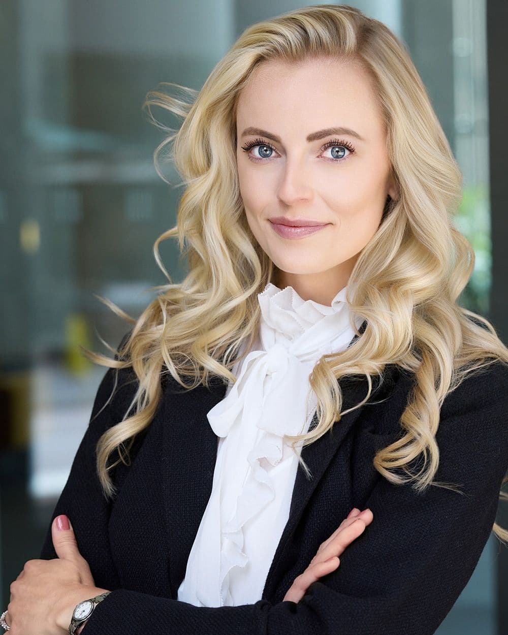 “Professional corporate headshot of a woman with arms crossed in a modern office setting, photographed in Denver.”
